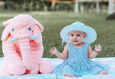 Une jolie petite fille avec son doudou géant éléphant. Découvrez nos collections!d'éléphant