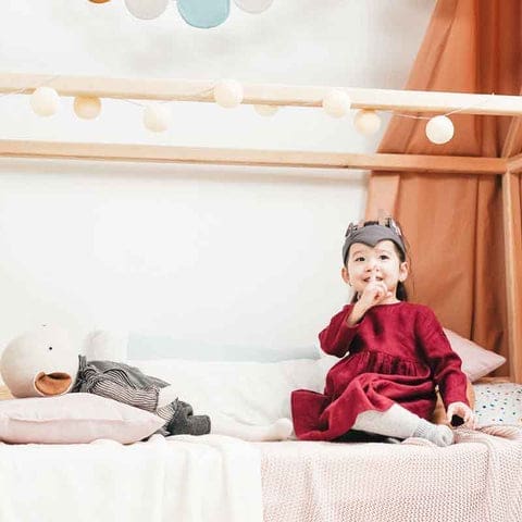 Fillette installée dans sa chambre avec ses jouets et un éclairage parfait