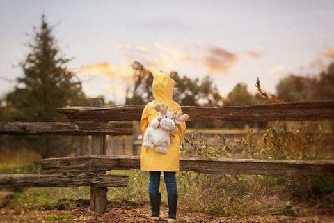 Enfan en ciré jaune avec son sac à dos peluche. Découvrez notre collection